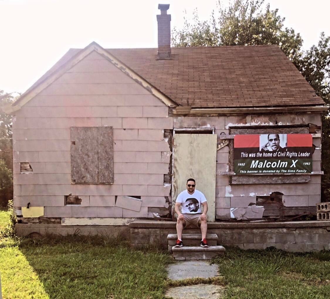 Dr. Tareq Ramadan sitting on the porch of Malcolm X's Inkster home.