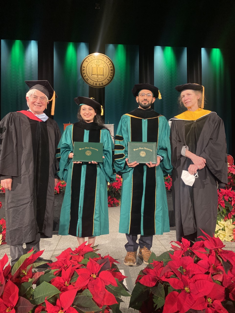 Professor David Njus and doctoral student Praneet Marwah with doctoral student Mohammed Bharmal and Professor Victoria Meller on stage