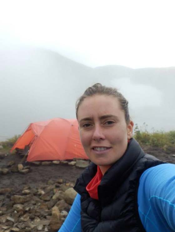 Dr. Jordan Sinclair doing field work in a cold, wet, rocky environment
