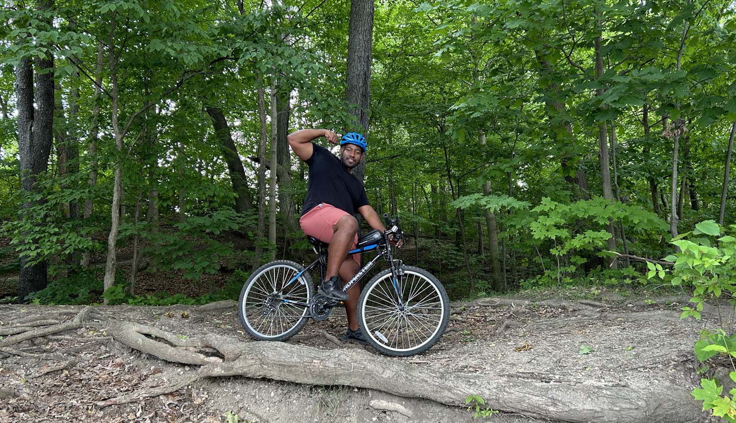 David on a bike holding a muscle flex pose