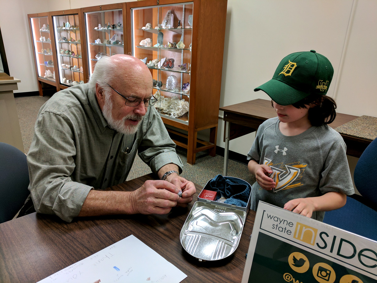 David Lowrie with a kid examining a specimen