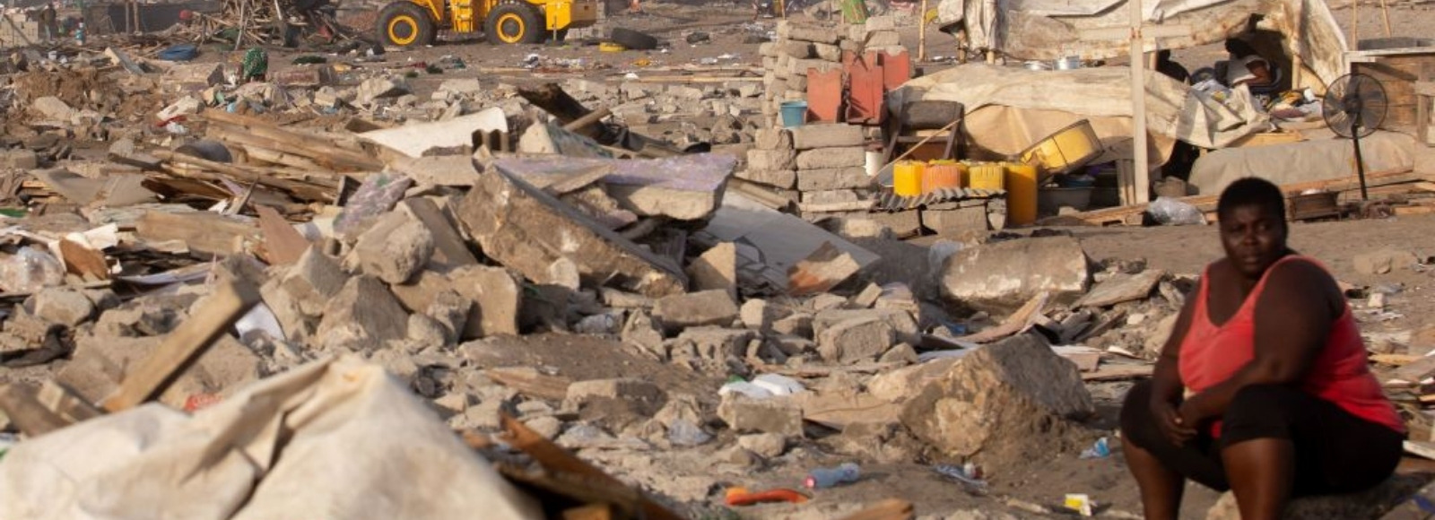 A woman sits at a site in James Town, Accra, demolished in May 2020 to make way for a new fishing port complex