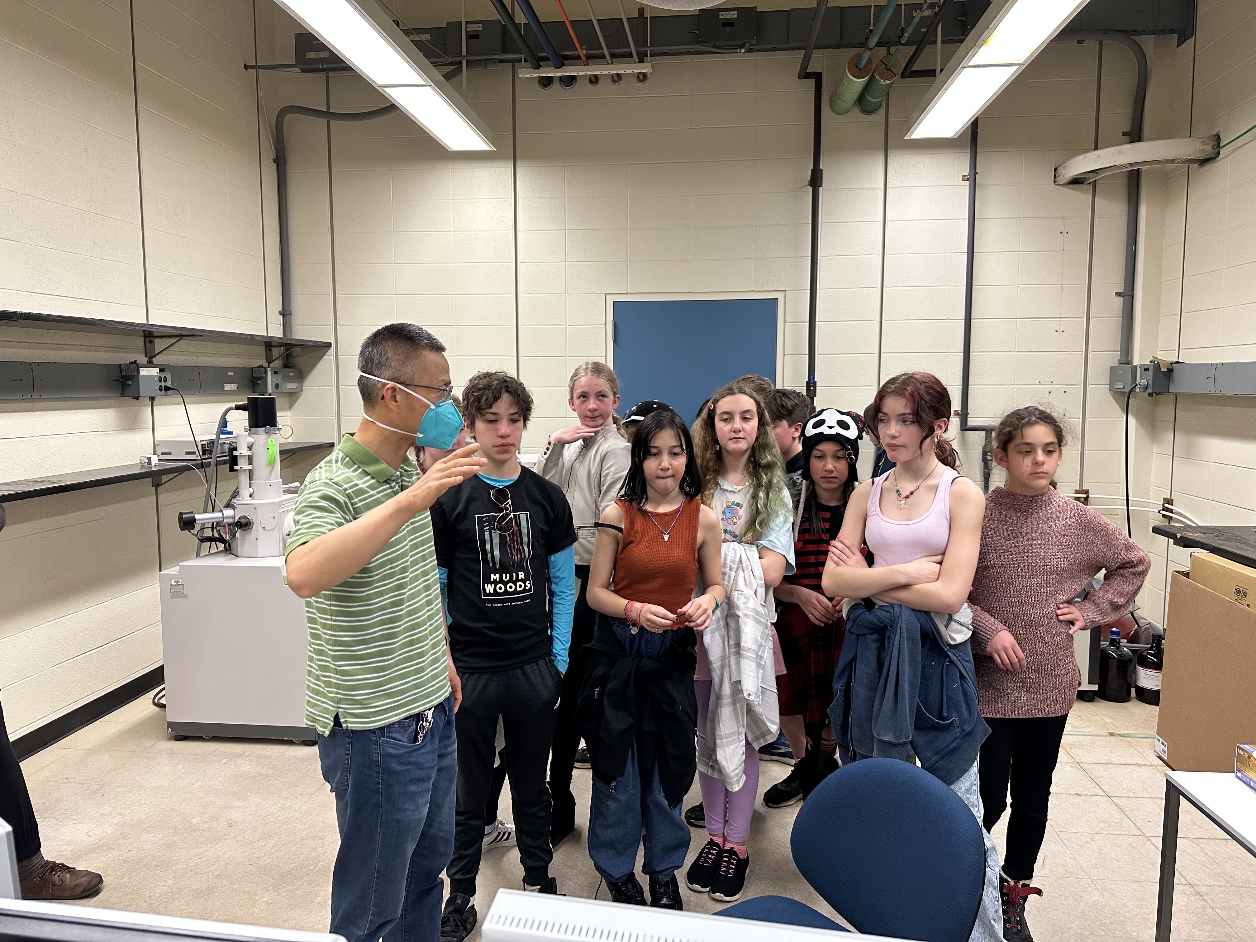 Sixth graders in a lab, listening to Prof. Zhou's explanations
