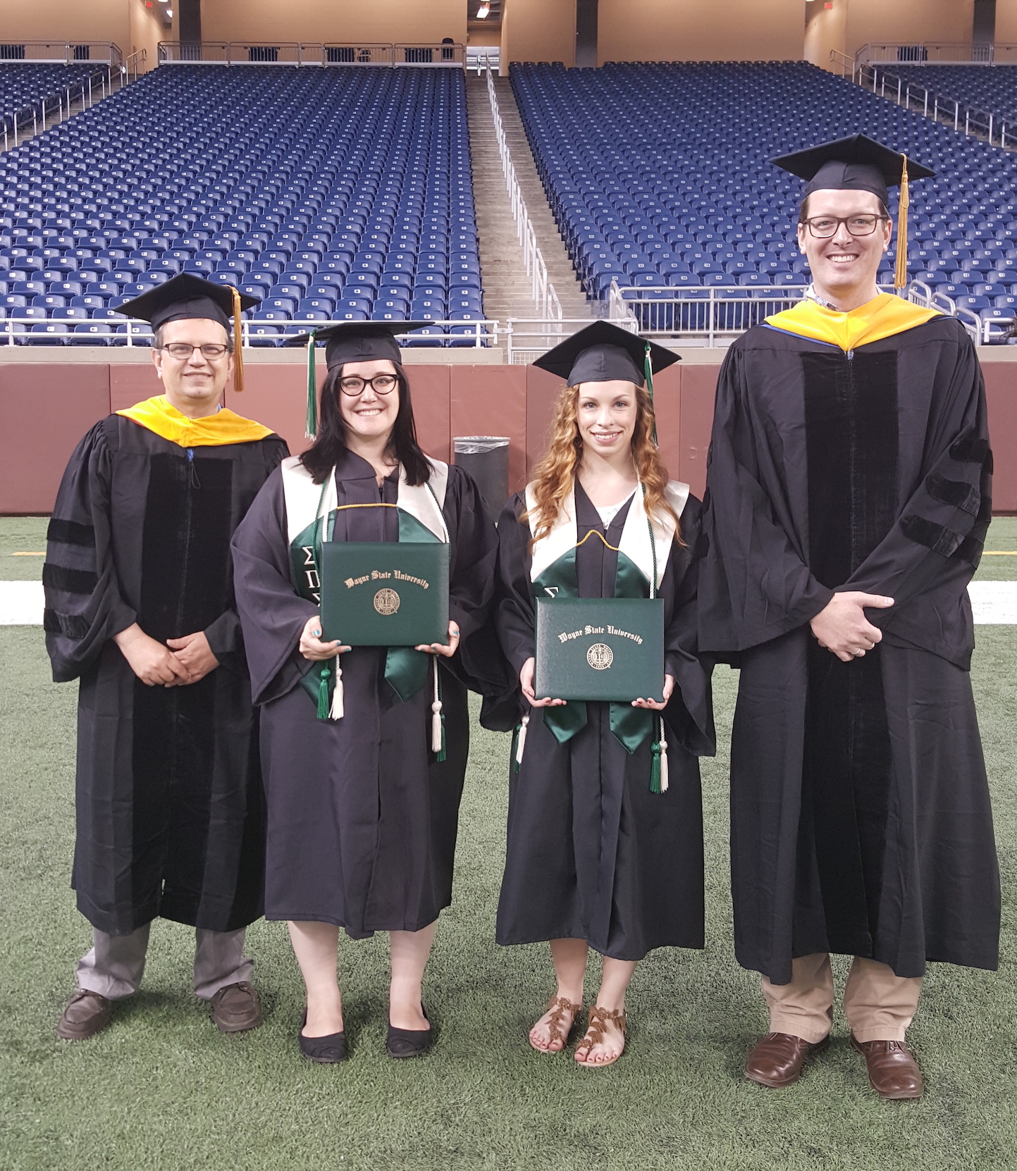 Graduates Renee Ludlam and Rachael Merritt holding their degrees.