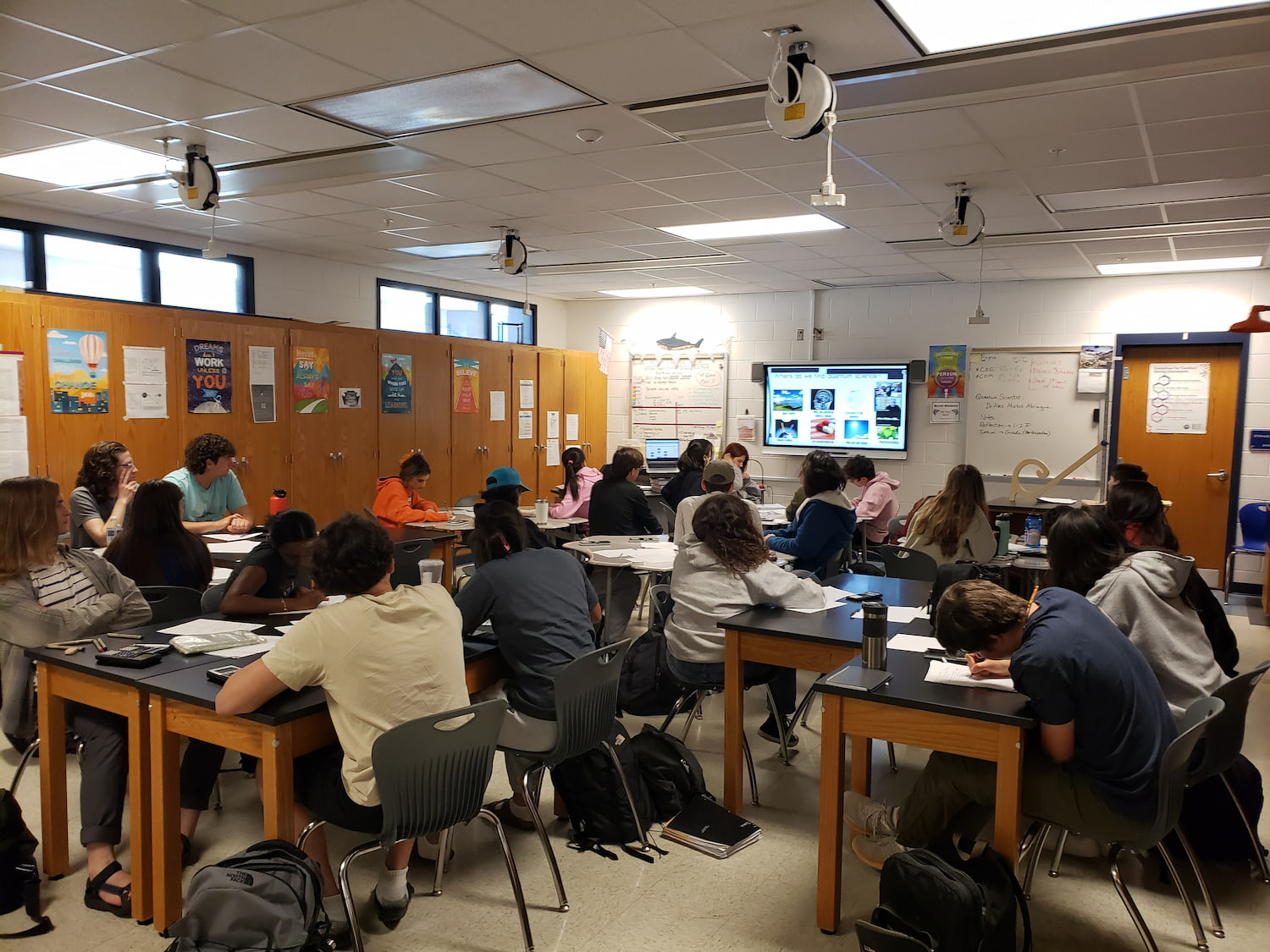 High school students in a classroom watching Prof. Matos Abiague presentation on an electronic board